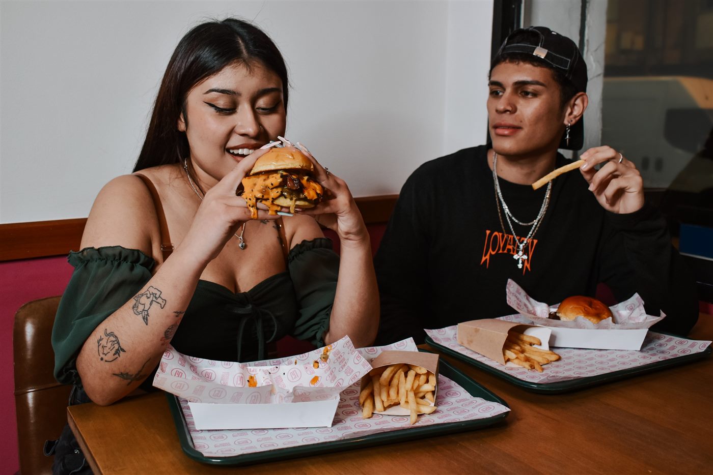 Chica y chico comiendo hamburguesas y patatas en Bubble Smash Martos