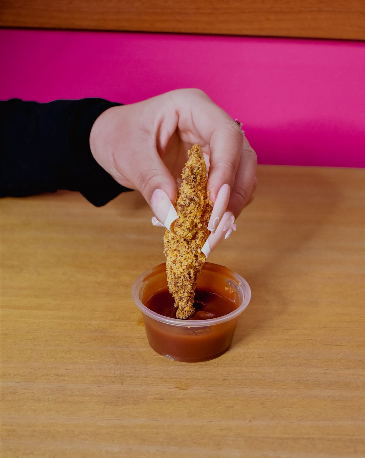 Finger de pollo mojando en salsa barbacoa